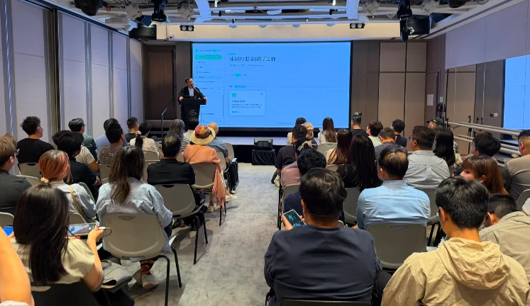 中小企 AI Agent 應用研討會現場:講者在台上,投影幕顯示 sparkAgent 回覆「我幫你完成了工作」,座位坐滿參加者。